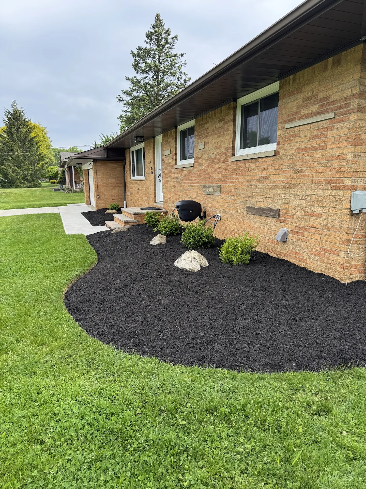 A yard with pristine mulch completed by Kings Court Landscaping